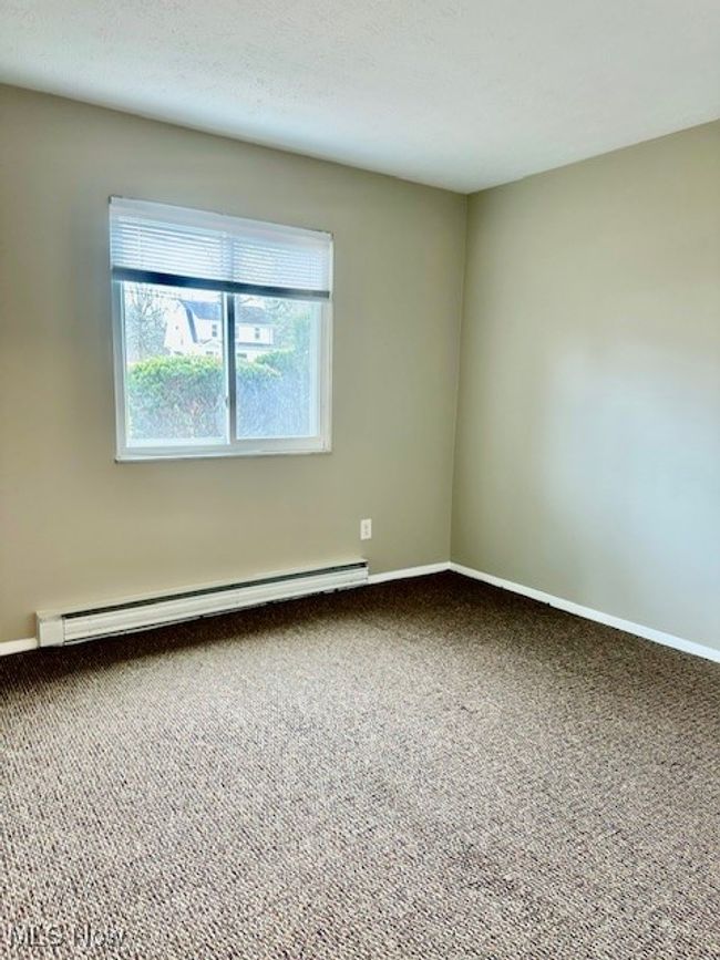 Carpeted spare room with baseboard heating and baseboards | Image 11