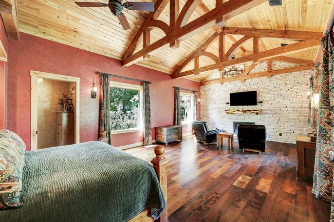 The primary suite includes exceptionally high ceilings, arch work, and a seating area. | Image 19