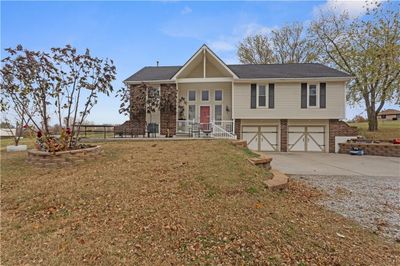 Bi-level home with a garage, a front lawn, and a porch | Image 1