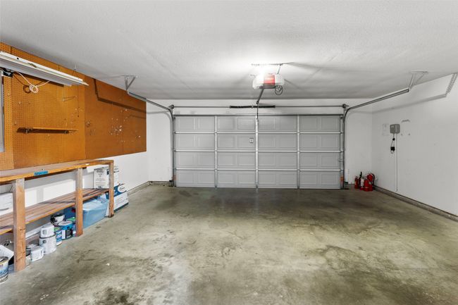 Garage featuring a garage door opener and a workshop area | Image 37