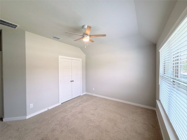 Unfurnished bedroom featuring carpet, vaulted ceiling, a closet, baseboards, and a ceiling fan | Image 18