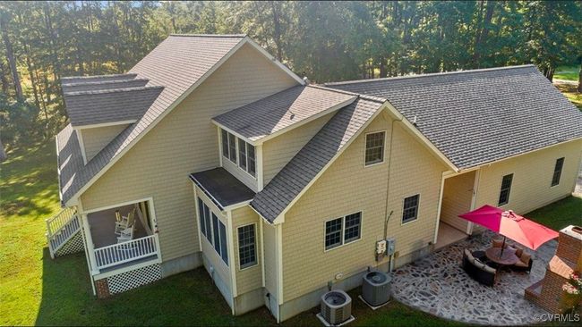 Rear view of property featuring a lawn, a shingled roof, and a patio area | Image 4