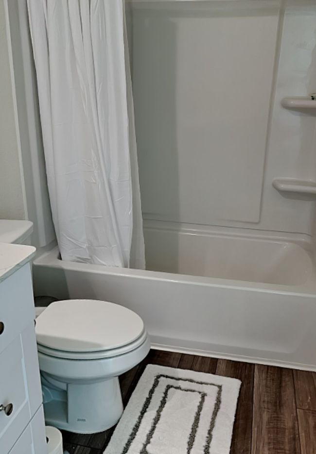 Full bathroom featuring vanity, shower / bath combo with shower curtain, and wood finished floors | Image 27
