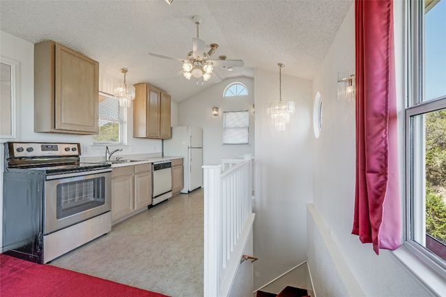 Taking the stairs to the 3rd floor, the Full Kitchen features all electric appliances, light brown cabinetry and ceiling fan | Image 19