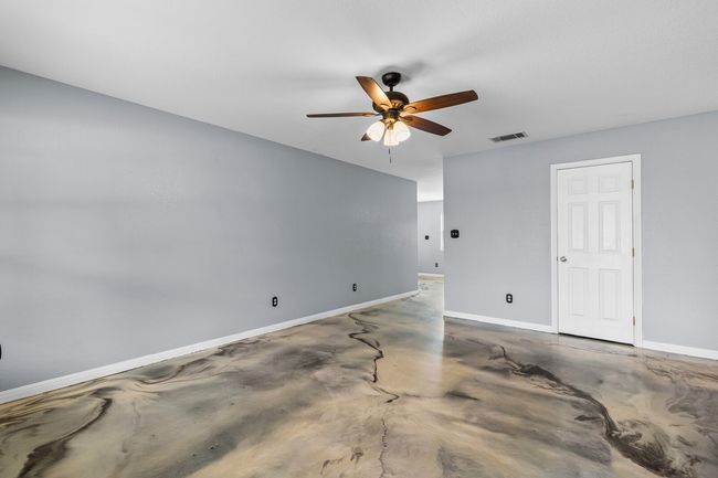 Empty room featuring a ceiling fan and concrete floors | Image 15