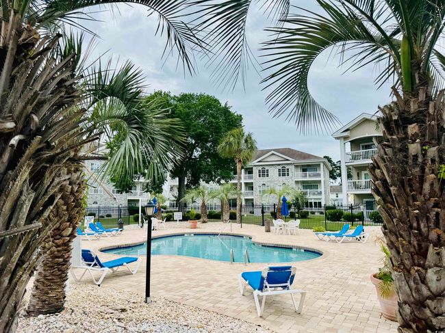 Community pool with fence and a patio area | Image 9