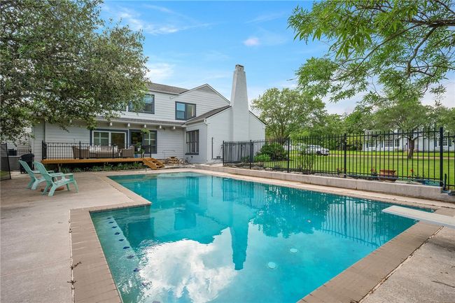 View of pool with a deck, a patio, and a diving board | Image 32