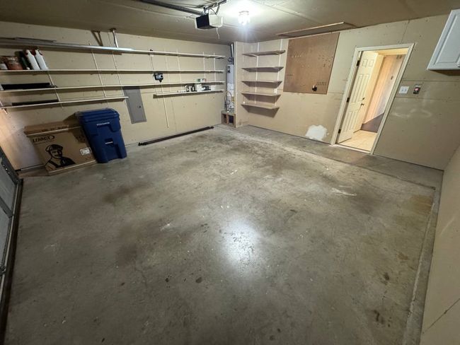 Garage with electric panel, water heater, and a garage door opener | Image 14