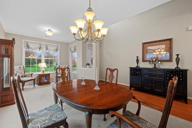 The open living area when you enter the unit is adorned by windows and has crown molding detail. | Image 24