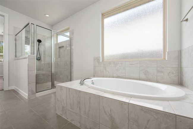 Full bathroom featuring healthy amount of natural light, a shower stall, and a garden tub | Image 20