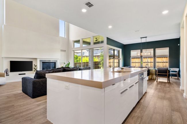 Kitchen with an island with sink, white cabinets, modern cabinets, plenty of natural light, and recessed lighting | Image 13