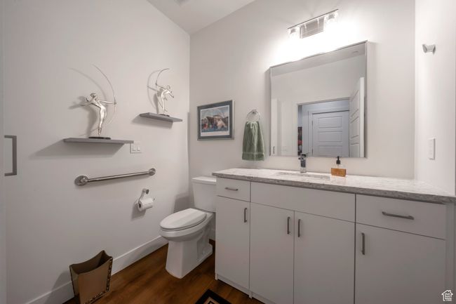 Bathroom with vanity, wood finished floors, toilet, and baseboards | Image 12