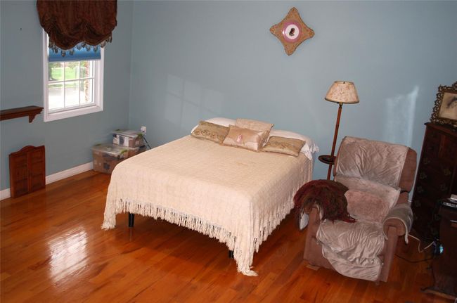 Bedroom with wood finished floors and baseboards | Image 24