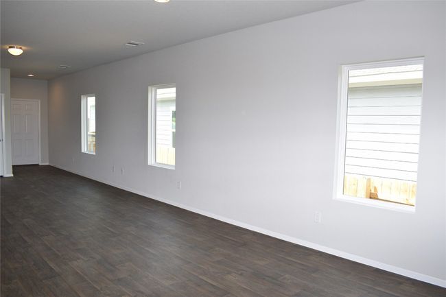 Empty room with dark wood-type flooring and recessed lighting | Image 7