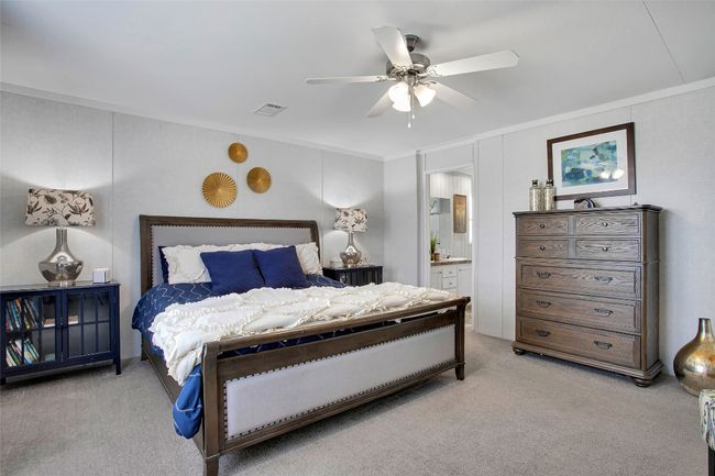 Bedroom with light carpet, ornamental molding, ensuite bath, and ceiling fan | Image 16