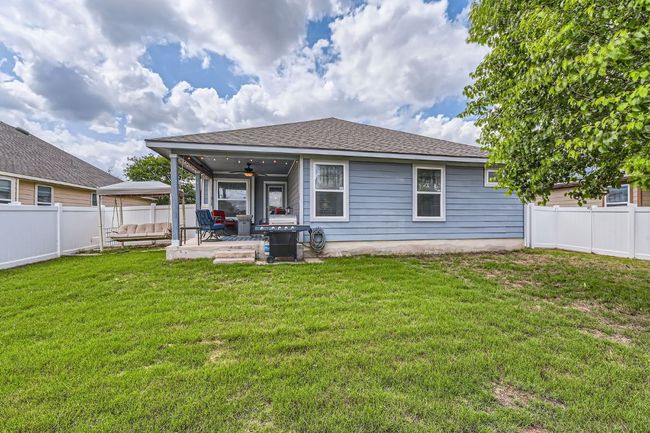 Back of house with a fenced backyard, a gazebo, a ceiling fan, a patio area, and a lawn | Image 26
