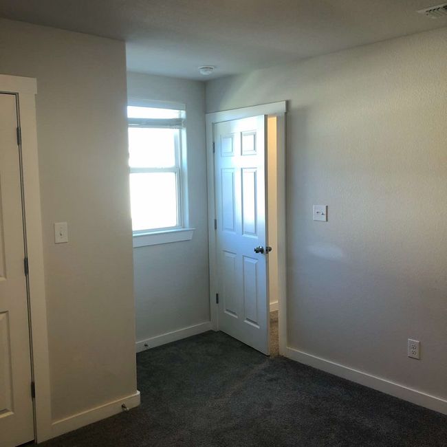 Unfurnished room featuring dark colored carpet and baseboards | Image 11
