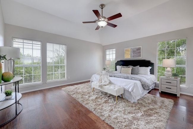 Bedroom with baseboards, vaulted ceiling, dark wood-style floors, and ceiling fan | Image 21