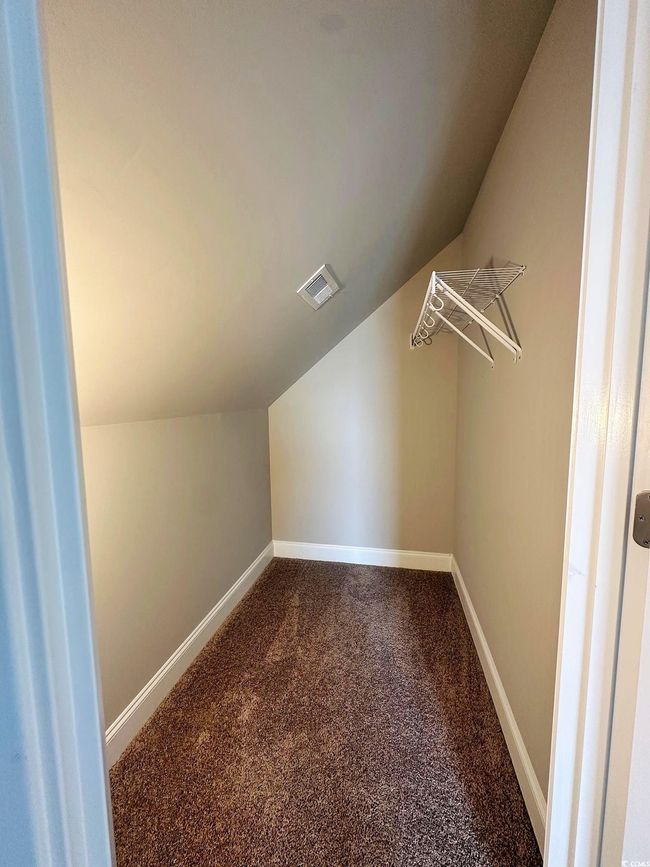 Bonus room with baseboards, vaulted ceiling, a ceiling fan, visible vents, and dark carpet | Image 18
