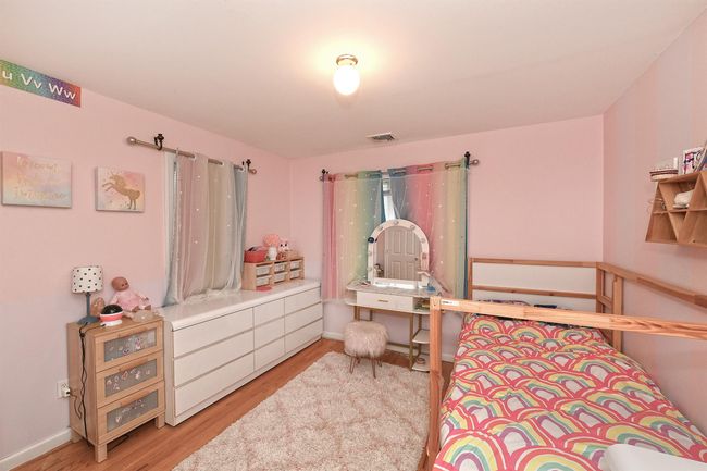 Bedroom featuring baseboards, visible vents, and wood finished floors | Image 7