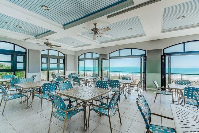 Sunroom with view of water and beach, healthy amount of natural light, coffered ceiling, and beamed ceiling | Image 40