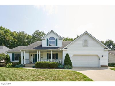 View of front of house with covered porch, a garage, and a front lawn | Image 1