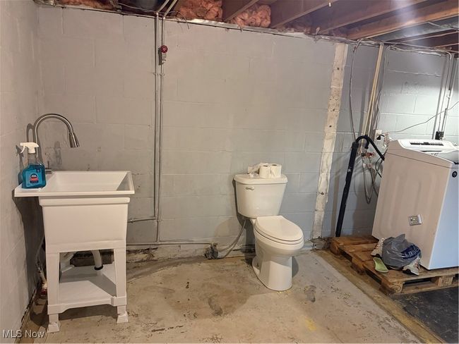 Bathroom featuring toilet, concrete floors, and washer / clothes dryer | Image 18