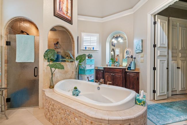 Bathroom with tile patterned flooring, vanity, a bath, a shower stall, and crown molding | Image 24