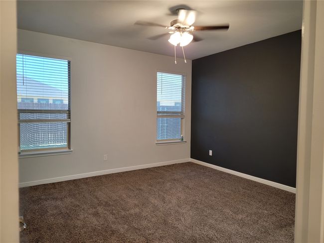 Carpeted empty room featuring ceiling fan and baseboards | Image 13