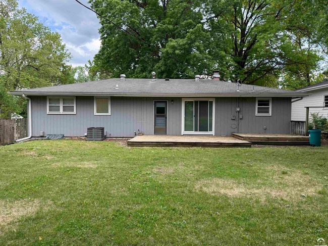 Two tiered wood deck, yard with flowers, partially fenced by neighbors | Image 13