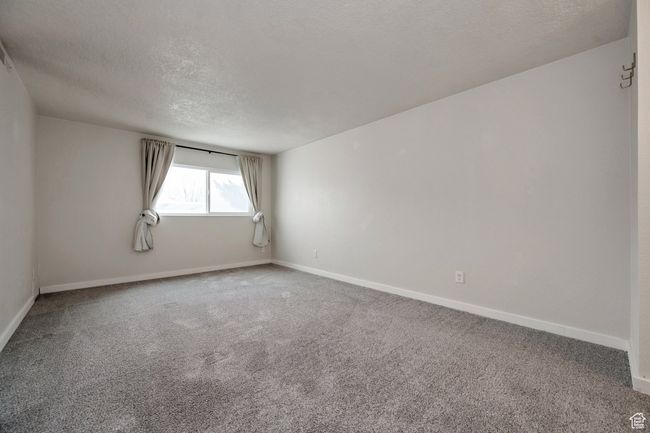 Carpeted spare room with a textured ceiling and baseboards | Image 11