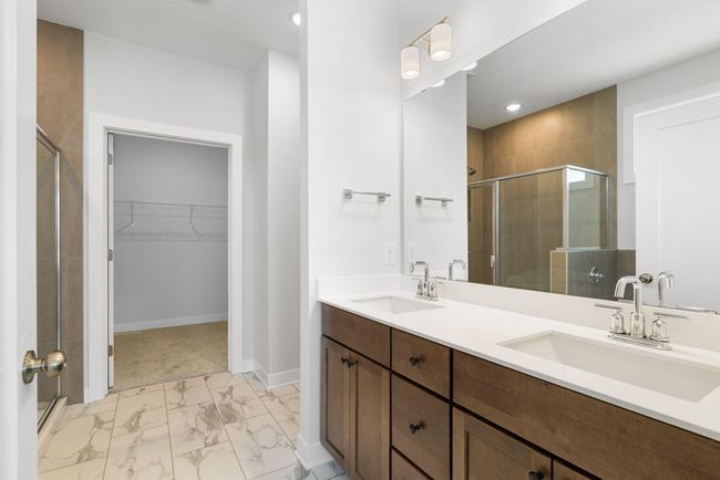 The luxurious master bathroom features dual vanities, offering ample storage and convenience for busy mornings. With a spacious layout and elegant finishes, this serene retreat is perfect for unwinding at the end of the day. | Image 23