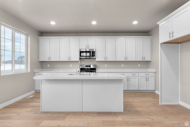 Kitchen with stainless steel appliances, light countertops, baseboards, and recessed lighting | Image 10