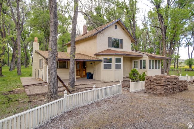 View of front of property with a chimney, stucco siding, and roof with shingles | Image 5