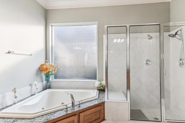 Standing shower features a hand sprayer & a seat. Tub for the ultimate relaxation to soak your day away! | Image 20