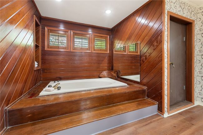 Full bath featuring wooden walls, wood finished floors, and a garden tub | Image 28