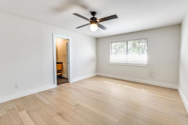 Empty room with ceiling fan, light wood-style floors, and baseboards | Image 19