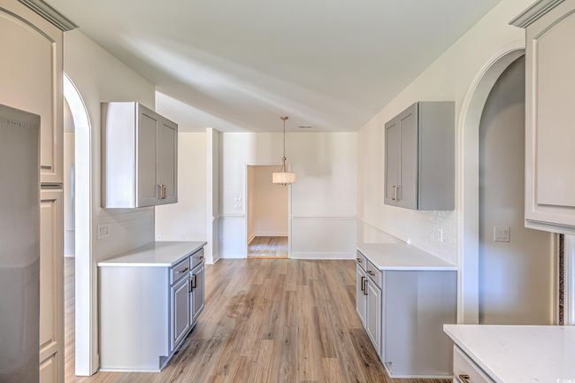 Kitchen with gray cabinetry, light countertops, and backsplash | Image 25