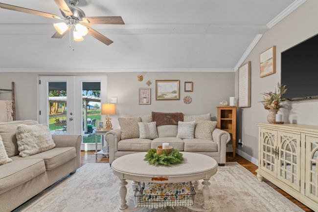 Living area with ornamental molding, a ceiling fan, and wood finished floors | Image 21