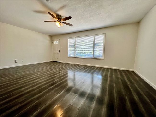 Empty room with baseboards, ceiling fan, and dark wood-type flooring | Image 10