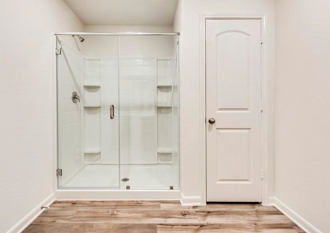 Bathroom with a stall shower, baseboards, and wood finished floors | Image 8