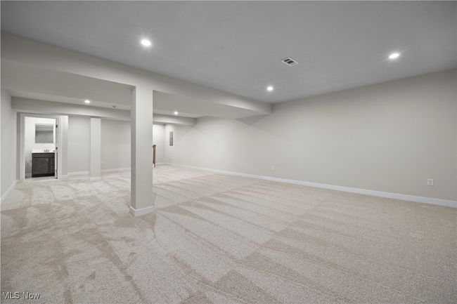Finished basement with light carpet, baseboards, visible vents, and recessed lighting | Image 27