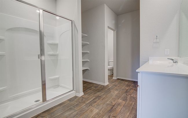 Full bathroom with a shower stall, vanity, toilet, and wood finished floors | Image 18