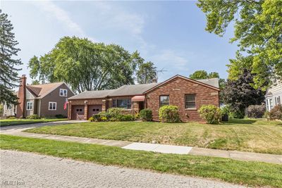 View of front of home with central AC, a front yard, and a garage | Image 2