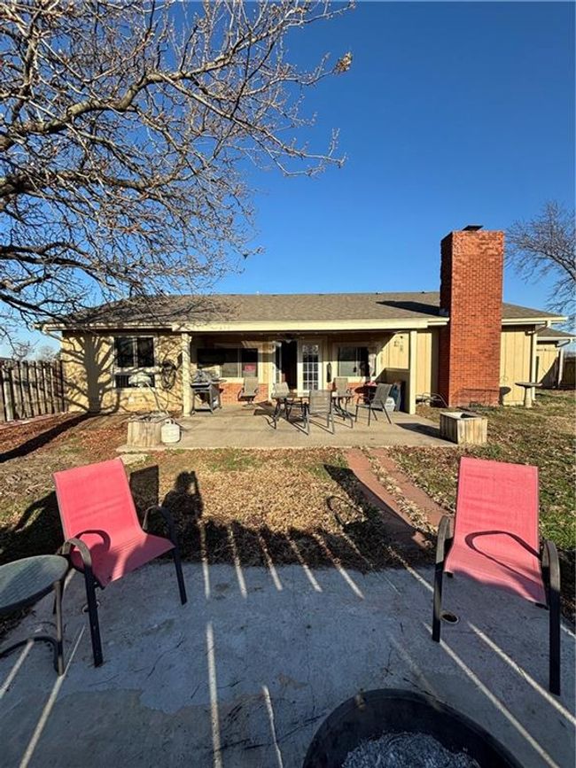 Rear view of property with privacy fence and two patio areas | Image 27