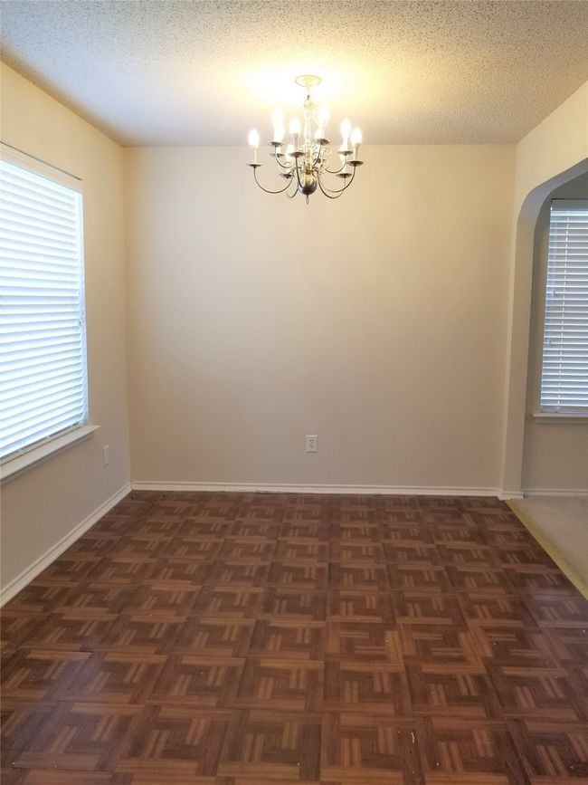 Unfurnished room featuring a chandelier, arched walkways, and a textured ceiling | Image 7