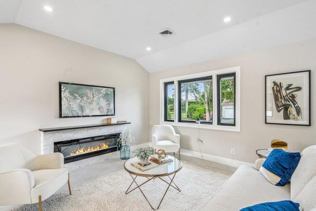 Living room featuring vaulted ceiling, recessed lighting, and a stone fireplace | Image 11
