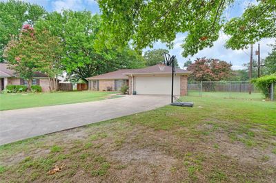 Ranch-style house featuring a garage and a front yard | Image 3