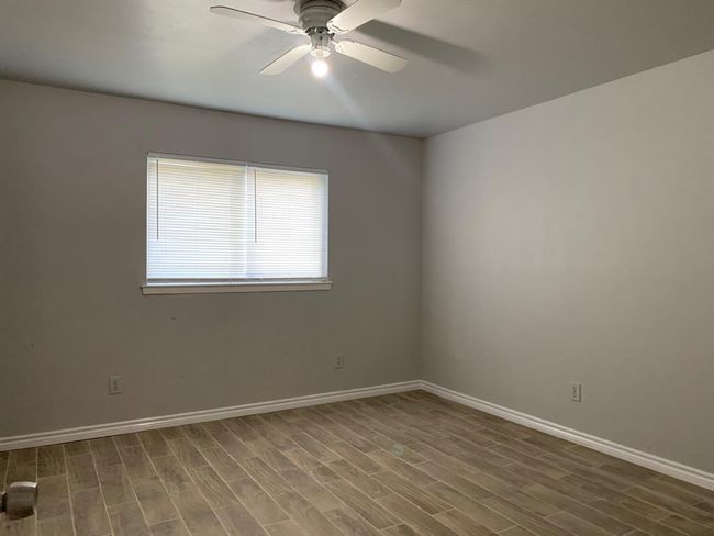 Empty room with hardwood / wood-style floors and ceiling fan | Image 9