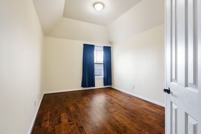 Bedroom featuring wood flooring, baseboards, and vaulted ceiling | Image 19